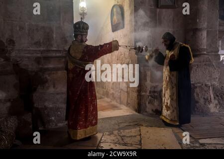 Un prêtre copte orthodoxe et arménien censurant avec thurible à l'intérieur de l'église du Saint-Sépulcre dans la vieille ville de Jérusalem Israël Banque D'Images