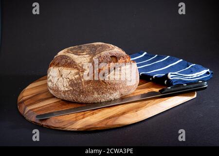 Pain de seigle sur une planche en bois avec un fond noir Banque D'Images