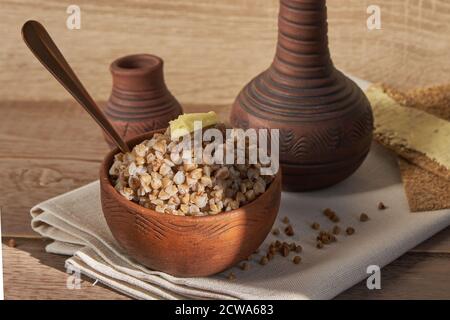 sarrasin cuit avec une tranche de beurre servi avec des chips de seigle sur une table en bois. Banque D'Images