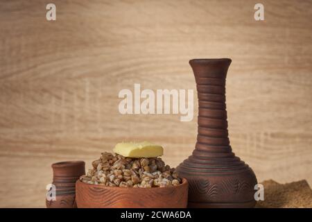 sarrasin cuit avec une tranche de beurre servi avec des chips de seigle sur une table en bois. Banque D'Images