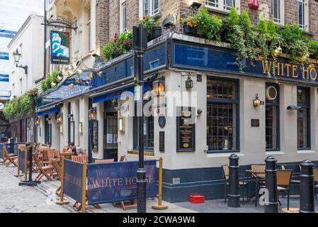 Un homme solitaire assis à une table sur le trottoir devant le pub White Horse à Newburgh Street, Soho, Londres, Angleterre, Royaume-Uni Banque D'Images