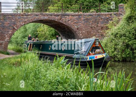 Un bateau à rames passe sous Sedgleys Bridge sur le canal de Grand Union près de Great Bowden, Leicestershire, Angleterre. Banque D'Images