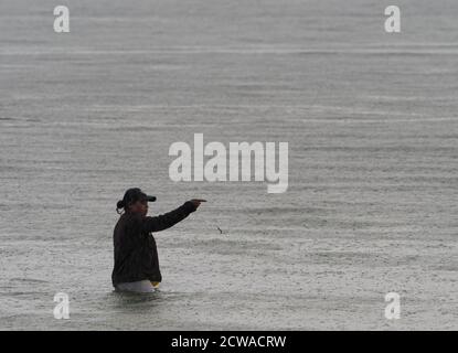 Kaimana, Indonésie - 7 février 2018 : silhouette de pêcheur à marée haute sur la mer de Saram. Kaimana, péninsule de Bird's Head, Papouasie occidentale, Indonésie Banque D'Images