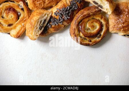 Variété de pains à pâte feuilletée traditionnels français avec rason et chocolat, croissant sur fond de texture blanche. Plat, espace Banque D'Images