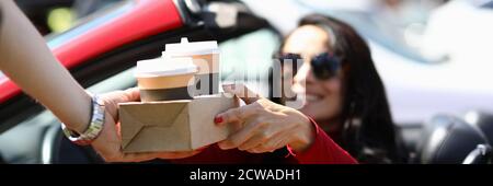 Une femme en voiture ramasse le café du service de messagerie de près Banque D'Images