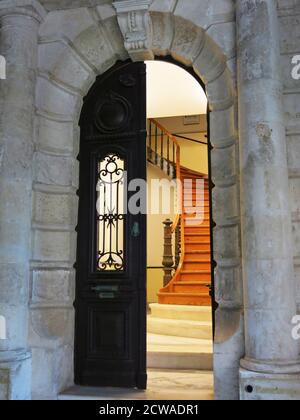 Entrée principale d'un bâtiment néoclassique avec un escalier en bois menant au 1er étage. Concept : architecture. Banque D'Images