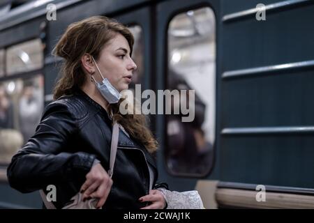 Moscou. Russie. 28 septembre 2020 UNE jeune femme portant un masque médical de protection se tient sur la plate-forme d'une station de métro, attendant de monter à bord du Banque D'Images