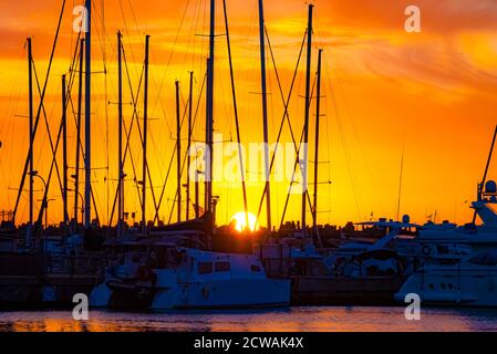 Les mâts de yacht sont silhouettés par un magnifique ensemble de soleil méditerranéen. Photographié en Israël Banque D'Images