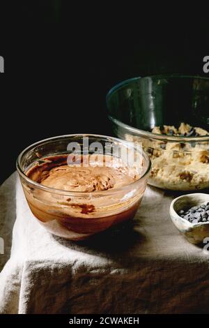 Tow types de pâte chocolat et sablés pour la maison pâtisserie brookies de dessert tendance brownies et biscuits dans des bols en verre, avec des copeaux de chocolat sur le lin Banque D'Images