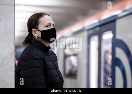 Moscou. Russie. 28 septembre 2020 UNE jeune femme portant un masque médical de protection se tient sur la plate-forme d'une station de métro, attendant de monter à bord du Banque D'Images