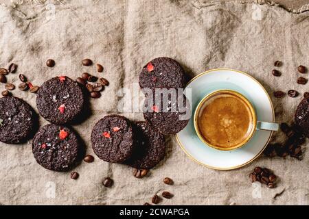 Chocolat noir maison brownies salées biscuits décorés de framboises séchées, avec flocons de sel, grains de café, menthe et tasse de café sur un chiffon Banque D'Images