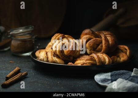 Petits pains à la cannelle traditionnels suédois servis sur une assiette. En-cas très populaire dans toute la Scandinavie. Banque D'Images