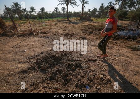 Bagdad, Irak. 29 septembre 2020. Un jeune homme inspecte un cratère causé par une attaque meurtrière à la roquette Katyusha près de l'aéroport international de Bagdad. Deux roquettes katyusha lancées vers l'aéroport de Bagdad ont frappé une maison voisine et ont tué et blessé plusieurs personnes lundi, a déclaré dans une déclaration le Commandement des opérations interarmées de l'armée. Credit: Ameer Al Mohmedaw/dpa/Alamy Live News Banque D'Images