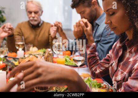 foyer sélectif famille multiculturelle avec les yeux fermés tenant la main thanksgiving Banque D'Images