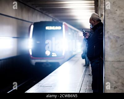 Moscou. Russie. 28 septembre 2020. Un homme âgé aux cheveux gris dans un masque médical de protection avec un téléphone portable dans sa main se tient sur la plate-forme de Banque D'Images