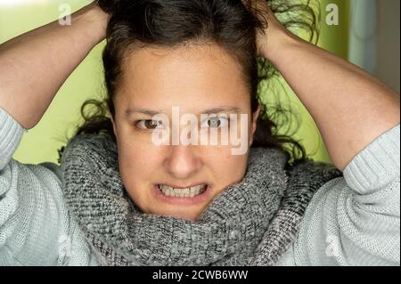 Une jeune femme avec un look en colère tire ses cheveux. Banque D'Images