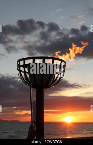 Prestwick, Ayrshire, Écosse Royaume-Uni 05 juin 2012 allumer un phare à Prestwick Beach pour célébrer les Jeux olympiques de 2012 avec l'île d'Arran et le Firth of Clyde Ground, le soleil coulait, il y a donc une lueur des sunlight.beacons,ou feux à éclats, étaient des feux qui ont été allumés pour avertir les gens locaux de l'approche d'un ennemi.Ils ont été installés sur de hautes collines, généralement dans le cadre d'un système de signaux défensifs, ou chaîne, s'étendant de la côte aux zones intérieures.Le signal a été donné par la fumée pendant le jour et la lumière la nuit. Banque D'Images