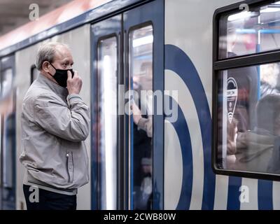 Moscou. Russie. 28 septembre 2020. Un homme âgé aux cheveux gris dans un masque médical de protection se tient sur la plate-forme d'une station de métro, attendant un Banque D'Images