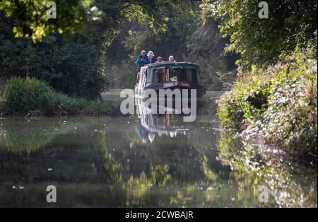 Un bateau sur le canal est conduit le long du canal de Basingstoke, près de Dogmersfield, dans le Hampshire. Banque D'Images