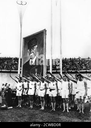 Les athlètes saluant les fascistes au Parc des Princes, Paris, 1941. Un portrait massif du maréchal Petain, chef du régime de Vichy, se dresse derrière eux. Le photographe est inconnu. Banque D'Images