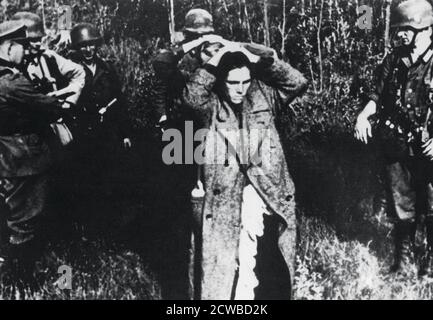 Soldats allemands avec prisonniers russes, Russie, 1941. L'opération Barbarossa, l'invasion allemande de l'Union soviétique, a été lancée le 22 juin 1941. Comme les Allemands avançèrent vers l'est, ils ont pris beaucoup de prisonniers comme ils ont encerclé des armées Rusiennes entières. Derrière les lignes, les SS ont commencé à arrondir la population juive et les commissaires politiques communistes. Le photographe est inconnu. Banque D'Images