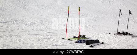 Équipement de ski : bâtons de ski, skis sur une piste enneigée éclairée par le soleil en hiver. Vue panoramique. Banque D'Images