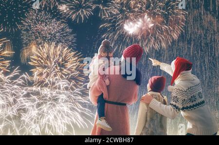 Vacances du nouvel an. Parents et filles les filles regardent des feux d'artifice. Bonne famille sur la neige randonnée d'hiver dans la nature. Vacances saison d'hiver. Banque D'Images