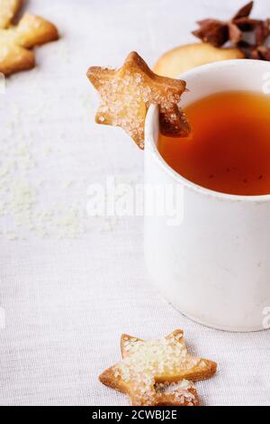 Biscuits de Noël sablés pour des tasses sur une tasse de millésime de chaud thé sur table avec nappe blanche et sucre vert Banque D'Images