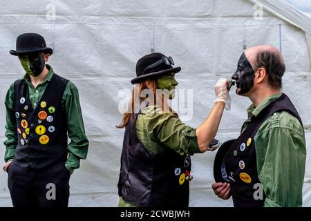 Un groupe de danseurs Morris appliquant leur maquillage avant de jouer à la Harfield Village Fete, Hartfield, East Sussex, Royaume-Uni. Banque D'Images