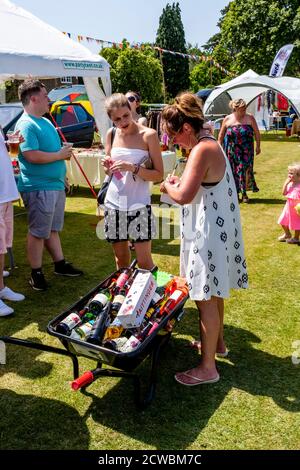 Les gens locaux devinent le nombre de bouteilles dans la brouette «le tonneau de Booze» à Nutley Village Fete, Nutley, East Sussex, Royaume-Uni. Banque D'Images