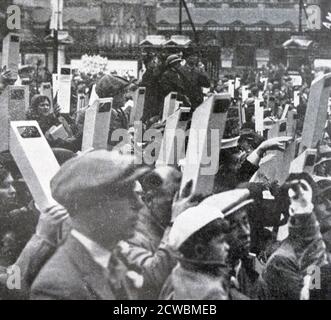 Photographie en noir et blanc le jour du couronnement du roi George VI du Royaume-Uni (1895-1952; Roi de 1936), le 12 mai 1937. Les gens bordent les rues de Londres pour essayer de voir la Royal Cortege. Banque D'Images