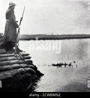 Photo noir et blanc de la vie sur le front; un soldat français tient une garde au-dessus d'une plaine inondée à la frontière franco-belge. Banque D'Images