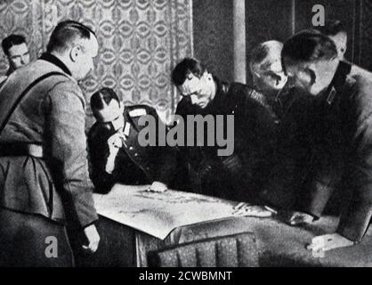 Photographie en noir et blanc de la guerre en Pologne; des officiers allemands et russes partitionnent la Pologne sur une carte. Banque D'Images