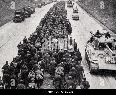 Photographie en noir et blanc de la Seconde Guerre mondiale (1939-1945) montrant l'image de la fin de la guerre en Europe; les forces alliées maintenant une colonne de prisonniers allemands marchant sur une route près de Berlin. Banque D'Images