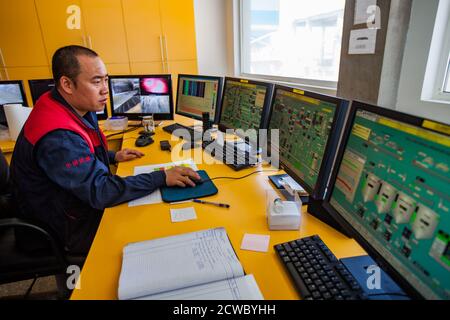 Centre de contrôle de l'exploitation de l'usine de ciment Jambyl. Moniteurs d'ordinateur et opérateur homme asiatique. Banque D'Images