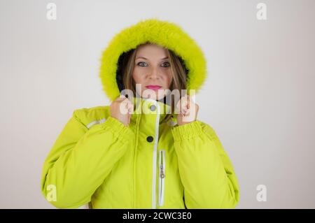 Belle femme en vêtements d'hiver. Femme porte une veste verte d'hiver chaude avec une capuche sur sa tête Banque D'Images