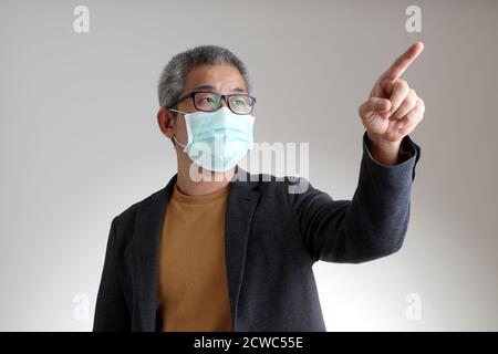 L'homme asiatique dans une ambiance décontractée et élégante debout sur fond blanc. Banque D'Images