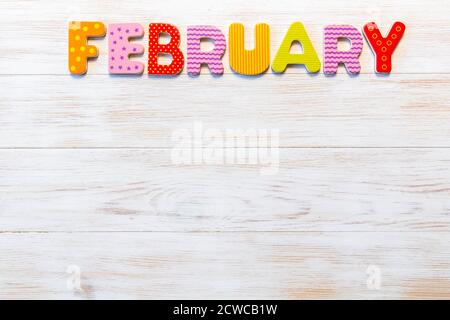 Lettres en bois écrites le mois de février sur fond vintage. Inscription janvier avec espace copie. Vue de dessus. Maquette pour les événements de calendrier. 12 mois Banque D'Images