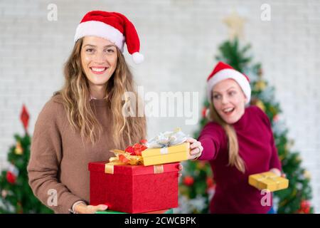 Deux amies riant et partageant des cadeaux de Noël. Fête de Noël et fête du nouvel an Banque D'Images