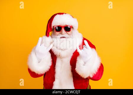 Gros plan portrait de son il sympa cool naughty blanc-cheveux Santa St Nicholas montrant le signe de double corne métal lourd isolé sur vif vif vif Banque D'Images