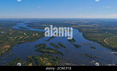 Vue panoramique aérienne du delta du fleuve Zambesi devant les chutes Victoria, le Bush et le village de Livingstone en arrière-plan. Banque D'Images