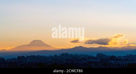 Rayons de soleil éclairant le volcan Cayambe au lever du soleil, Quito, Equateur. Banque D'Images