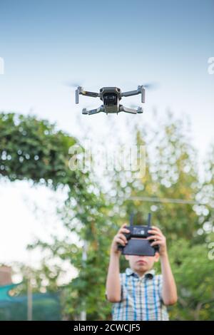 Enfant volant de drone. Garçon opèrent des drones. Quadcopter à fonctionnement enfant. Little Pilot utilisant la télécommande Drone Banque D'Images