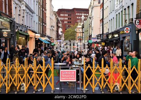 Le bar et le restaurant extérieurs temporaires regorgeant de personnes à Soho.des sections de Soho ont été bloquées pour la circulation afin de permettre des places temporaires dans la rue extérieure pour les bars et les restaurants pendant la pandémie de Covid-19. Banque D'Images