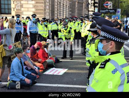 Londres, Royaume-Uni. 1er septembre 2020. La police, vêtue de masques faciaux, bloque la route tandis que les manifestants s'assoient pacifiquement pendant la manifestation de la rébellion d'extinction. Rébellion d'extinction les manifestants se sont emparée sur le terrain de la place du Parlement pour protester contre l'escalade de l'urgence climatique et pour exiger que le gouvernement agisse sur le changement climatique, l'élevage industriel et l'agriculture animale. Crédit : Vuk Valcic/SOPA Images/ZUMA Wire/Alay Live News Banque D'Images
