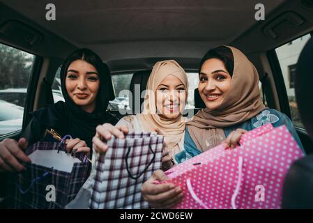 Trois femmes amies qui sortent à Dubaï. Les filles portant l'abaya traditionnelle des émirats arabes unis Banque D'Images