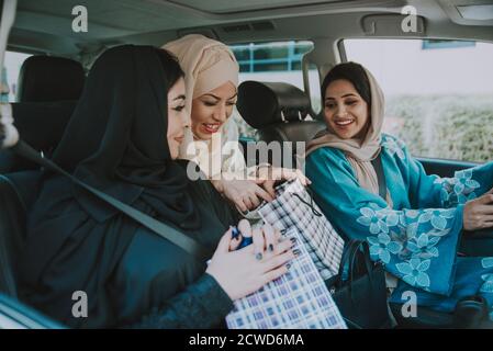 Trois femmes amies qui sortent à Dubaï. Les filles portant l'abaya traditionnelle des émirats arabes unis Banque D'Images