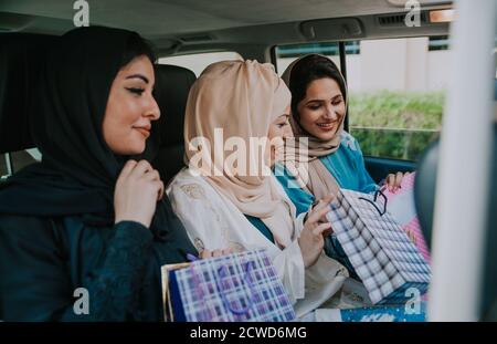 Trois femmes amies qui sortent à Dubaï. Les filles portant l'abaya traditionnelle des émirats arabes unis Banque D'Images