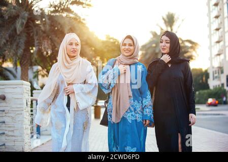 Trois femmes amies qui sortent à Dubaï. Les filles portant l'abaya traditionnelle des émirats arabes unis Banque D'Images