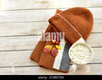 Toque et écharpe d'hiver chauds et délicieux chocolat chaud avec une crème à fouetter à déguster et à déguster en automne jours après les promenades dans les feuilles d'automne Banque D'Images